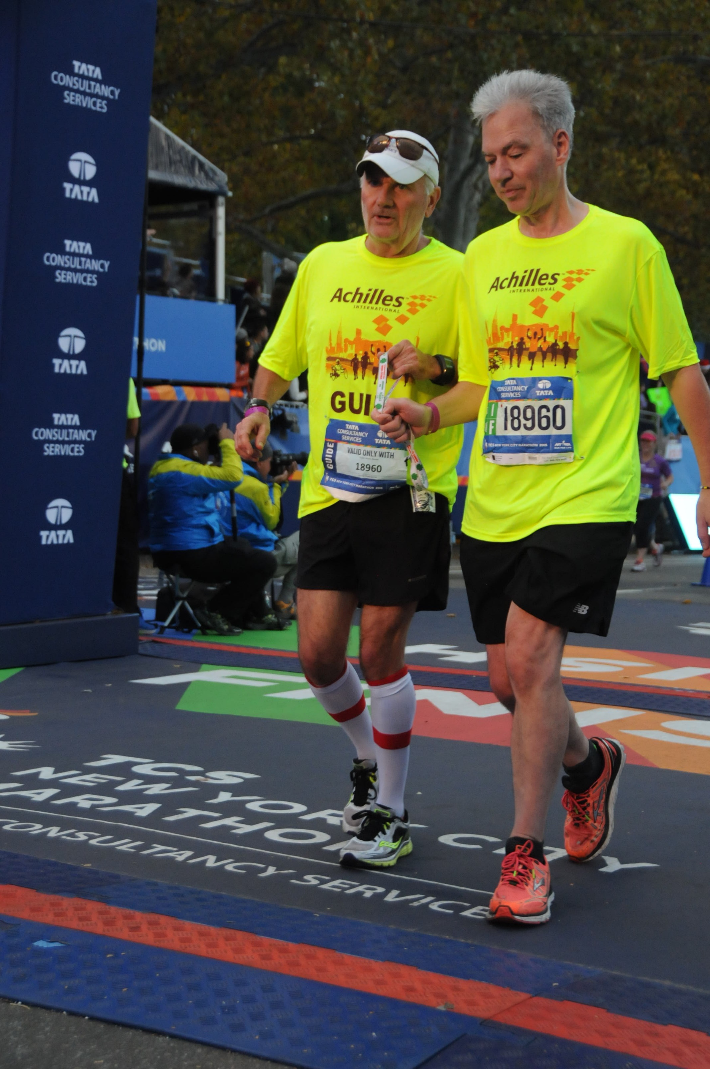 A male volunteer and a visually impaired athlete running together
