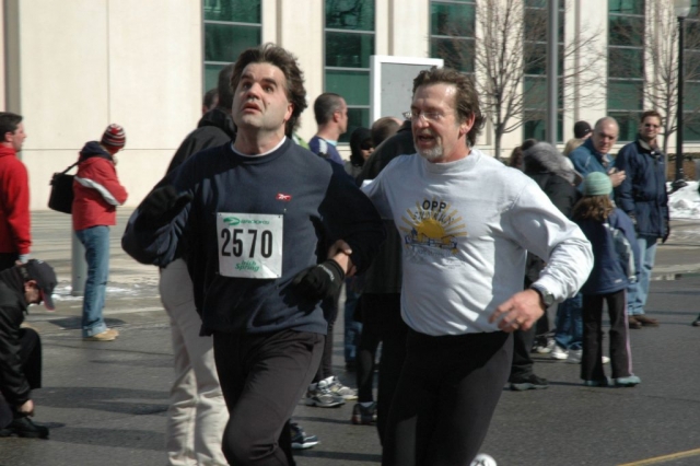 A male runner and a visually impaired runner participating in a marathon run